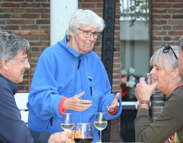 BBQ fidesta offingaburg ouderenzorg kleinschalig wonen samen eten en genieten vrouw drinken wijn glazen blauwe jas